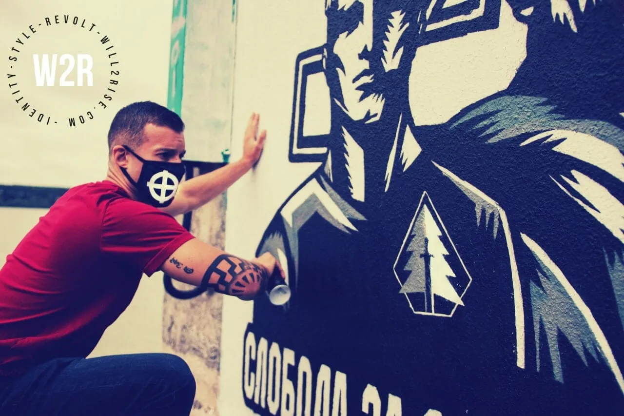 Rundo malující graffiti svého hnutí předcházejícího Active Clubs (R.A.M.) v Bělehradu. Na pravém lokti má vytetované černé slunce, emblém z mozaiky na zámku vůdce SS a jednoho z architektů holokaustu Heinricha Himmlera.